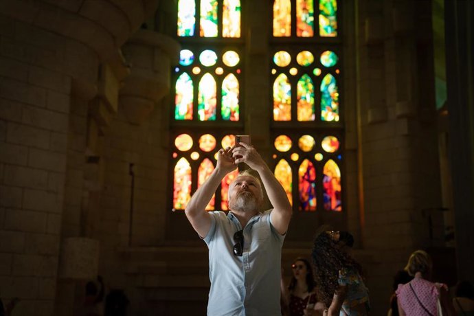 Archivo - Un hombre toma una fotografía del interior de la catedral de la Sagrada Familia durante la presentación del balance y las previsiones de obra de la Sagrada Familia, a 22 de septiembre de 2022, en Barcelona, Catalunya (España). 
