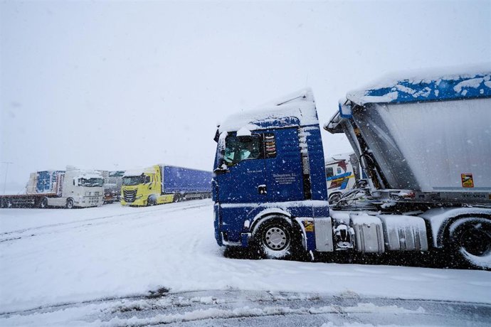 Varios camiones parados por la nieve
