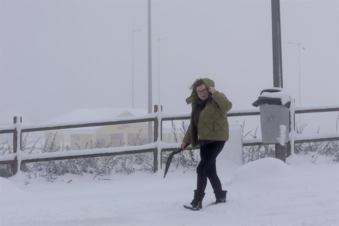 Una mujer camina por una calle cubierta de nieve, a 26 de enero de 2023, en Pedrafita do Cebreiro, Lugo, Galicia (España). Hay un corredor que forman el anticiclón al norte de la Península y una borrasca sobre el Mediterráneo, lo que está provocando dir