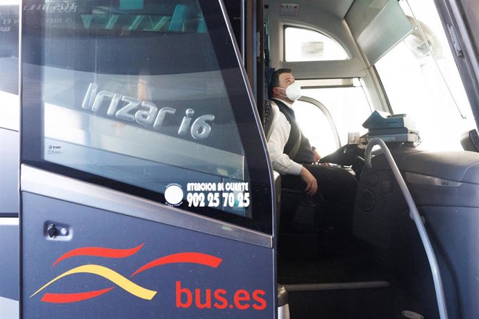 Un conductor montado en un autobús en una estación.