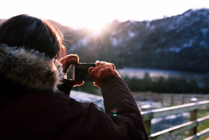 Persona usando el móvil para hacer una foto en el exterior