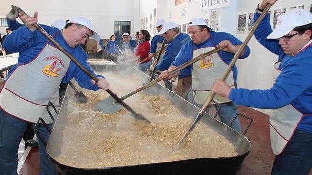 Voluntarios preparan migas en una edición organizada por la hermandad del Santo Entierro y el Ayuntamiento de Lora del Río.