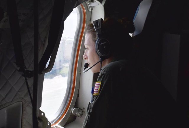 Una empleada de la Guardia Costera de Estados Unidos observa desde la ventanilla de un avión
