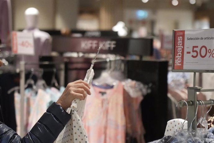 Imagen de archivo de una persona mirando ropa en un centro comercial