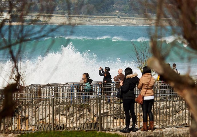 Archivo - Un grupo de personas observa el fuerte oleaje en Santander