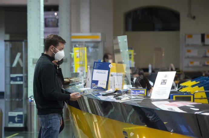 Archivo - Un cliente es atendiendo en la Oficina de Correos de Cibeles, en Madrid, (España)