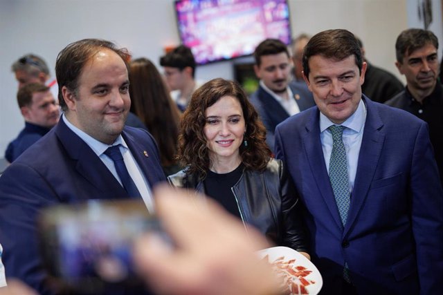 La presidenta de la Comunidad de Madrid, Isabel Díaz Ayuso (c), y el presidente de Castilla y León, Alfonso Fernández Mañueco (1d), posan con un plato de jamón durante la tercera jornada de Fitur 2023, en Madrid (España).