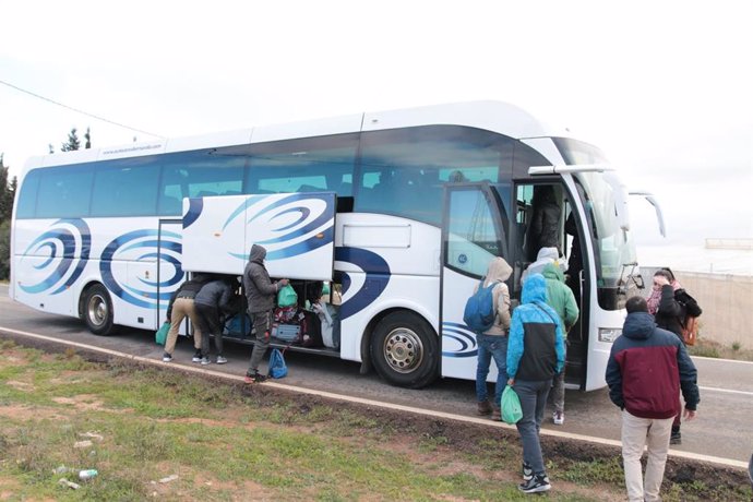 Moradores del asentamiento de El Walili, en Níjar (Almería), suben al autobús que los traslada a un centro de acogida temporal tras el derribo por orden judicial de sus infraviviendas