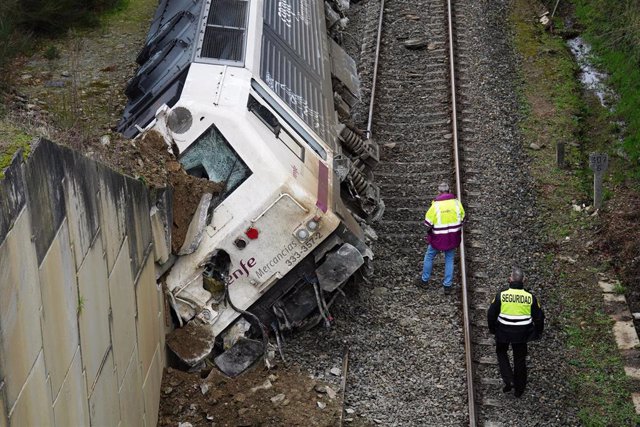 Dos hombres realizan las labores de retirada del tren accidentado, a 24 de enero de 2023, en A Xesta, Lalín, Pontevedra (España). 