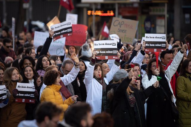 Varias personas protestan con pancartas y batas blancas durante una manifestación del sindicato médico Médicos de Cataluña por la huelga sanitaria, a 25 de enero de 2023, en Barcelona, Cataluña (España)