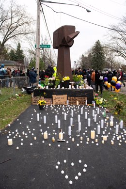 Archivo - Velas y flores depositadas en el suelo frente a un cartel del movimiento Black Lives Matter durante una vigilia en recuerdo de Daunte Wright en el lugar donde fue tiroteado mortalmente.