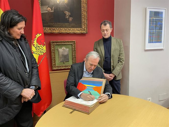 El alcalde de Zaragoza, Jorge Azcón, acompañado por la la concejala delegada de mayores y vicepresidenta del Patronato de La Caridad, Paloma Espinosa, y el director de la Fundación La Caridad, Daniel Gimeno, firmando en el Libro de Firmas.