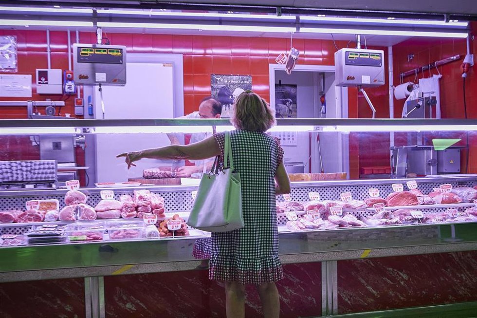 Archivo - Una mujer, frente a un puesto de carne en un mercado municipal.