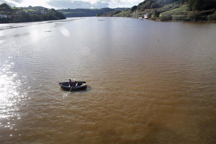 Un batuxo, embarcación tradicional del río Miño, surca las aguas del río Miño tras la crecida, a 2 de enero de 2023, en Portomarín, Lugo, Galicia (España).