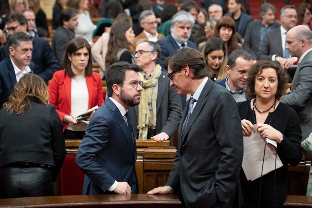 El president de la Generalitat, Pere Aragonès (i), i el líder del PSC, Salvador Illa (d), conversen durant una sessió plenària en el Parlament, a 26 de gener de 2023. Foto d'arxiu.