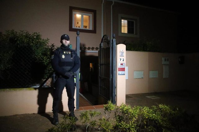 Un policía nacional custodia el domicilio en el que se han localizado los cadáveres de un hombre y una mujer muertos por disparos, a 31 de enero de 2023 en La Línea (Cádiz, Andalucía, España). 