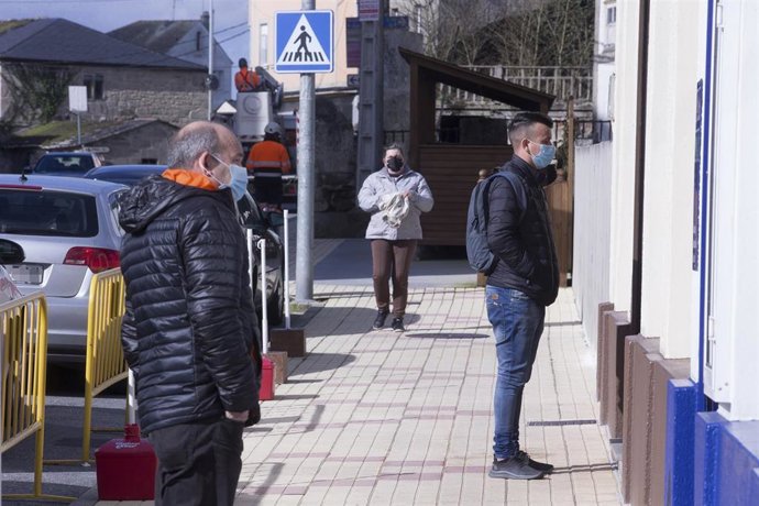 Archivo - Dos hombres observan un escaparate en el municipio gallego de Guitiriz, en Lugo, Galicia (España), a 17 de febrero de 2021. Esta localidad gallega ha contabilizado un total de 123 positivos en los últimos 14 días, lo que sitúa su incidencia ac