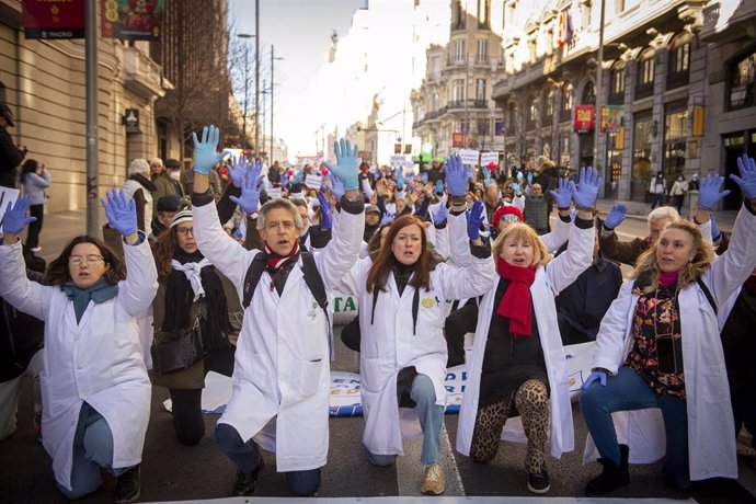 Varias personas con batas blancas y guantes azules protestan durante una marcha convocada por médicos y pediatras de Atención Primaria