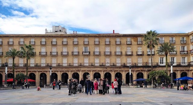 Turistas atienden las explicaciones de un guía en la Plaza Nueva de Bilbao