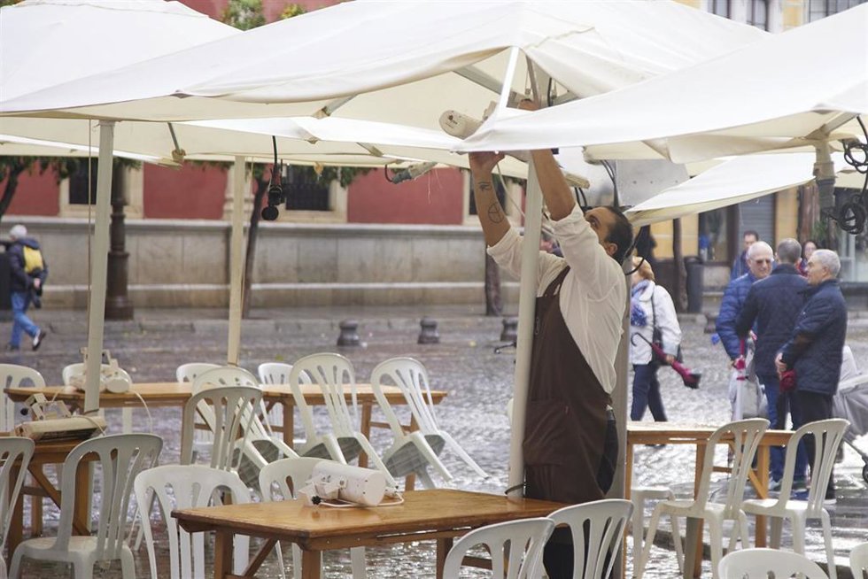Archivo - Un camarero pone los calefactores en una terraza.