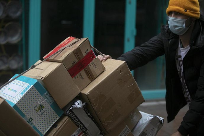 Archivo - Un repartidor lleva unas cajas 