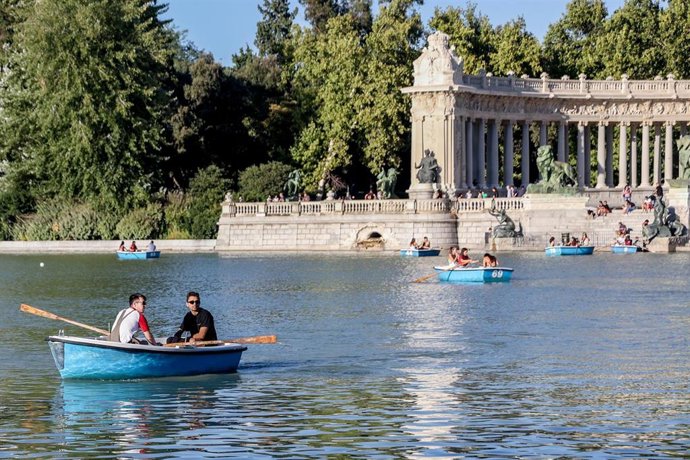 Archivo - Varias personas montan en barcas en el parque del Retiro