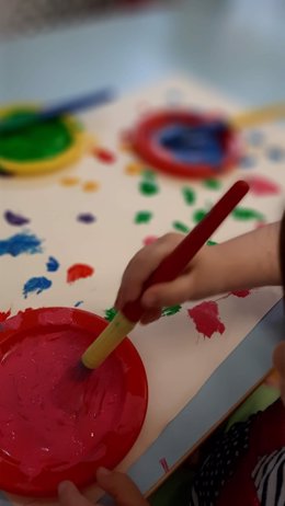 Un niño pinta en una escuela infantil