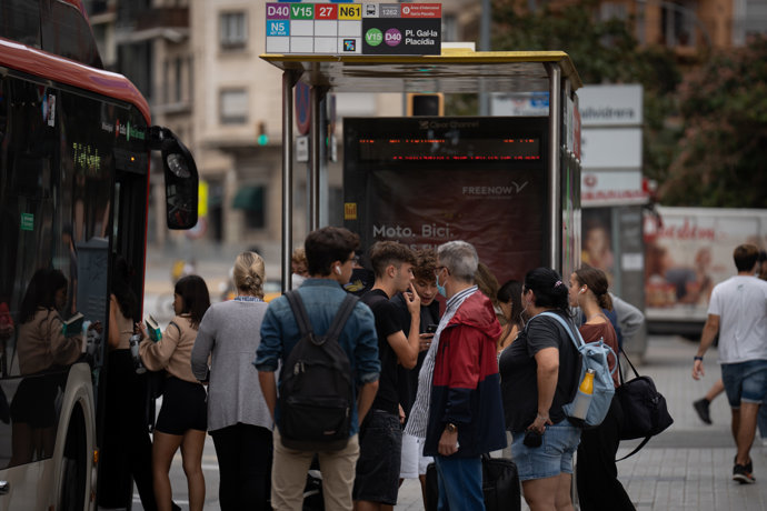 Varias personas esperan en la parada del autobús, a 23 de septiembre de 2022, en Barcelona, Catalunya (España).