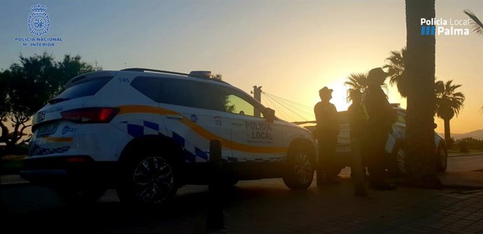 Archivo - Dos agentes, junto a un vehículo de la Policía Local de Palma.