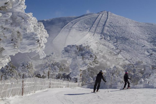 Dos personas esquían en la estación de esquí de Puerto de Navacerrada, a 29 de enero de 2023, en Sierra de Guadarrama, Madrid (España). Desde primera hora de ayer, primer día que abrían las pistas de esquí de la Sierra de Madrid esta temporada, y de hoy l