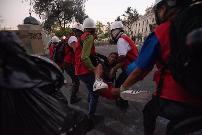 Manifestantes transportan a un herido en las protestas contra el Gobierno de Dina Boluarte en Lima, Perú.
