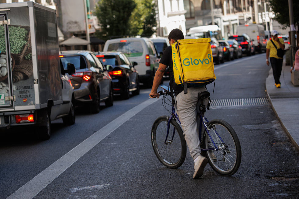 Un repartidor de Glovo en bicicleta por una calle del centro de Madrid