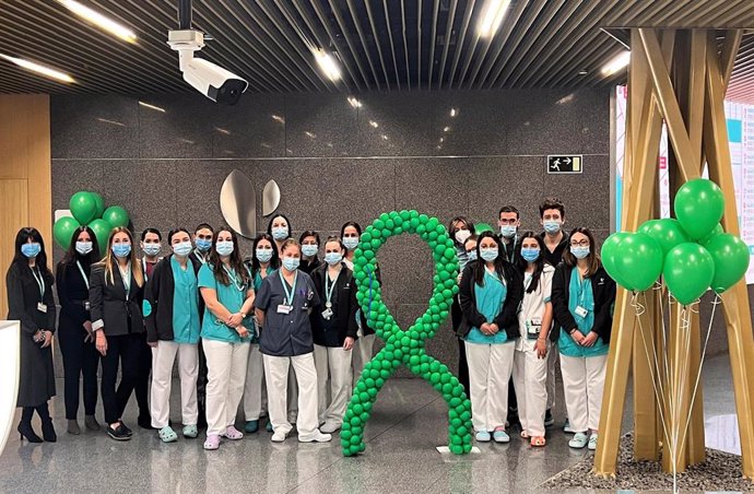 Profesionales del Hospital Quirónsalud Córdoba junto a globos y lazo de color verde, que representa la lucha contra el cáncer.