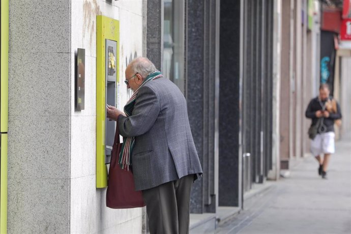 Archivo - Un hombre mayor saca dinero de un cajero.