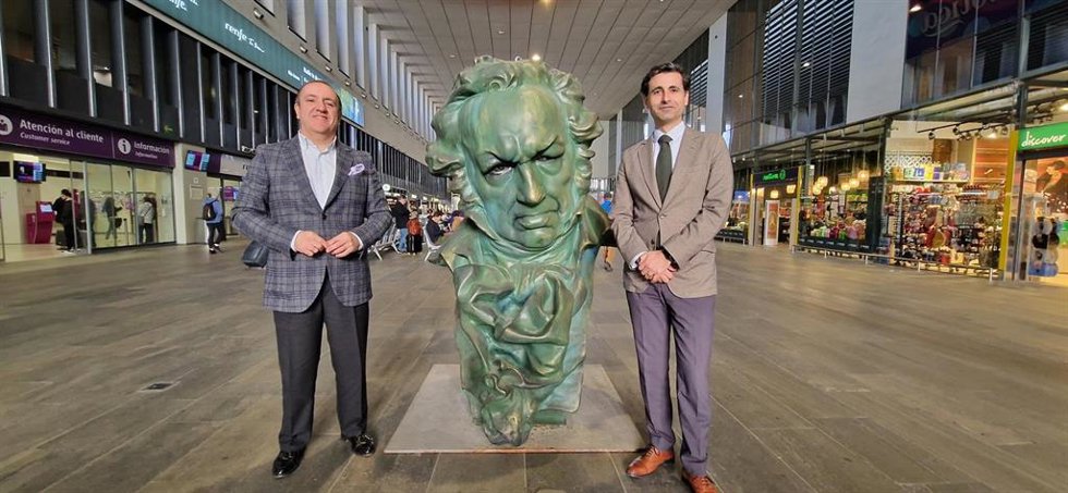 El subdirector de Estaciones Sur de Adif, Ángel García de la Bandera (a la derecha), y el delegado de Economía, Comercio y Turismo del Ayuntamiento, Francisco Javier Páez, junto a una réplica de los Goya en la estación de Santa Justa.