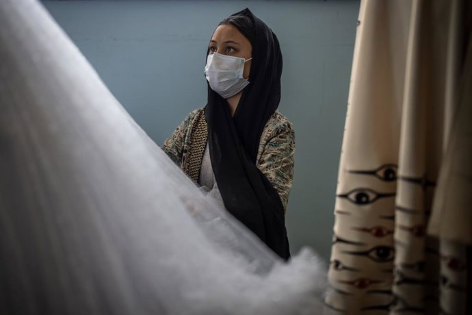 Archivo - 08 November 2022, Afghanistan, Kabul: A young Afghan woman works on a dress by Laila Haidari. In western Kabul, Haidari has founded an institute where women learn to make clothing and jewellery in order to earn an income, as well as courses in