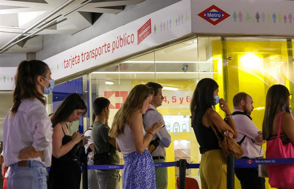 Archivo - Varias personas hacen cola para adquirir sus tarjetas de transporte en la estación de Sol. Archivo.