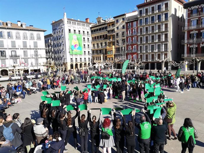 Un grupo de niños forma un lazo verde en la Plaza del Castillo con motivo del Día Mundial contra el Cáncer