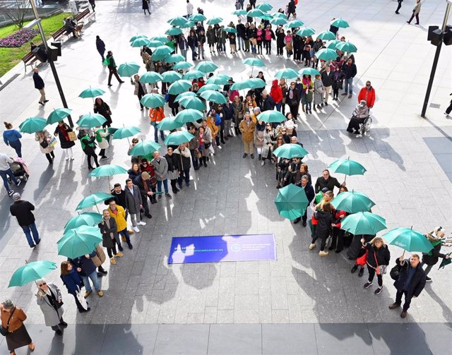 Decenas de personas forman un lazo humano contra el cáncer en la plaza del Ayuntamiento de Santander