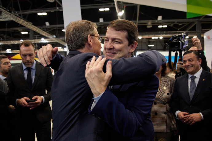 El presidente de la Junta de Castilla y León, Alfonso Fernández Mañueco (d), y el líder del PP, Alberto Núñez Feijóo (i), se saludan en la tercera jornada de la Feria Internacional de Turismo, Fitur 2023, en IFEMA Madrid