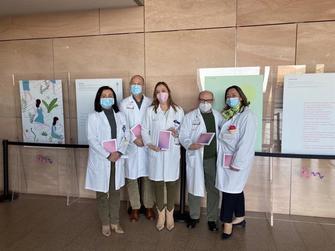 Personal sanitario posa junto a la exposición 'Una palabra. Una mujer. Una vida'