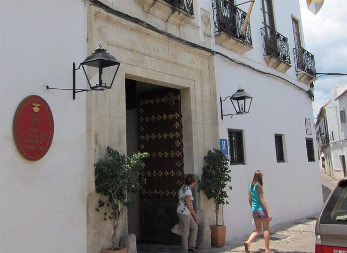 Archivo - Dos turistas salen de un hotel en el casco histórico de Córdoba.