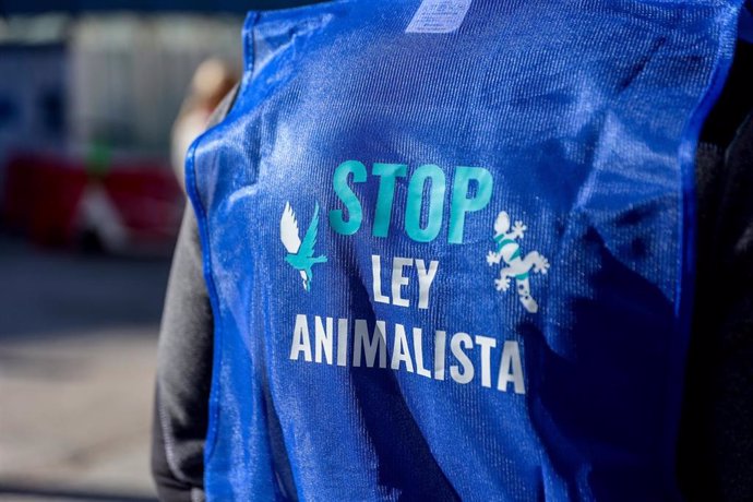 Una persona viste con un chaleco 'Stop Ley Animalista' durante una protesta contra la Ley del Bienestar Animal, a 5 de febrero de 2023, en Madrid (España). Representantes relacionados con el sector animal, comercios especializados y tiendas tradicionale