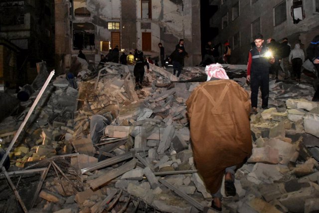 Personas inspeccionando un edificio destruido de 8 pisos en el barrio de Al-Arba'een en la ciudad de Hama después de un terremoto de magnitud 7,8 en la frontera entre Siria y Turquía