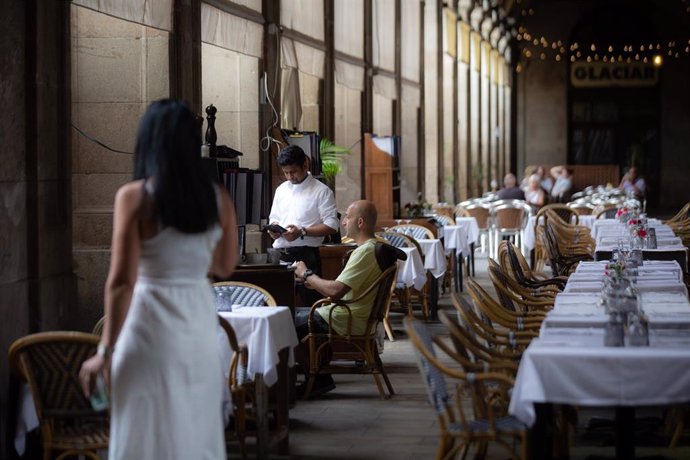 Archivo - Un camarero atiende a una mesa en la plaza Real de Barcelona, a 15 de junio de 2022, en una imagen de archivo.