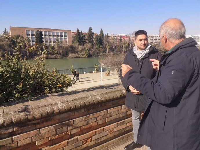 El candidato de IU a las municipales Ismael Sánchez con el ingeniero de Caminos Indalecio de la Lastra con la fábrica de tabacos de Altadis al fondo.