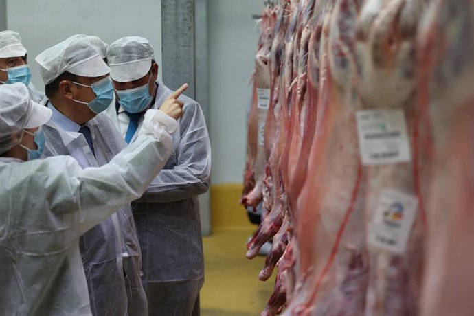 Archivo - El ministro de Agricultura, Pesca y Alimentación, Luis Planas (c), visita una explotación cárnica en Zaragoza.
