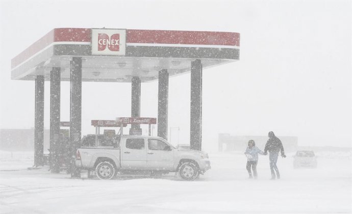 Archivo - Apr 06, 2008 - Horace, North Dakota, USA - GARY and KAREN ZIMMER battle blowing snow and gusty winds while walking back to their truck after paying for gas Sunday, April 6, 2008 at Cenex Kum & Go convenience store at Horace, N.D.  'I just want