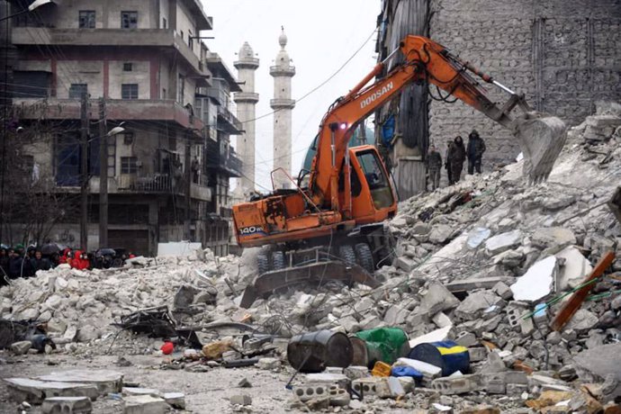Treballadors i voluntaris participen en tasques de rescat entre els enderrocs d'un edifici esfondrat a Alep després dels terratrmols ocorreguts prop de la frontera entre Turquia i Síria