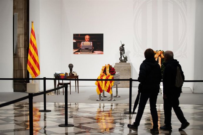 Dos personas visitan la capilla ardiente del escritor Josep Maria Espins, instalada en el Palau de la Generalitat, a 7 de febrero de 2023, en Barcelona, Catalunya (España). Durante la visita de Aragons a la capilla ardiente, el presidente de la Genera